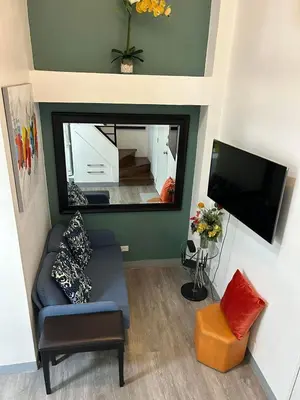 a living room with a couch and a large mirror at Simple but cozy, feel at home in Manila