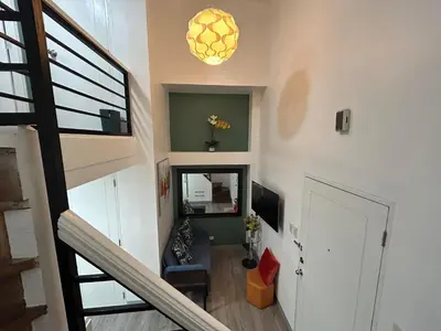 a living room with a staircase and a door at Simple but cozy, feel at home in Manila