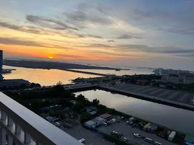 a sunset over a river with a parking lot at Seaside Manila Bay Sunset View at SM Mall of Asia in Manila