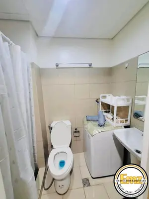 a bathroom with a white toilet and a sink at EMZ Shore Staycation 38 in Manila