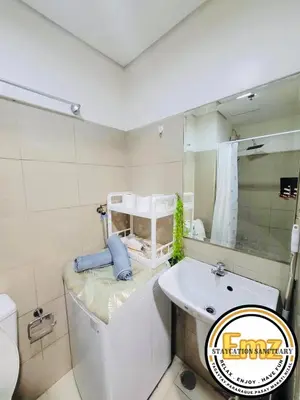 a bathroom with a tub and a sink and a mirror at EMZ Shore Staycation 38 in Manila