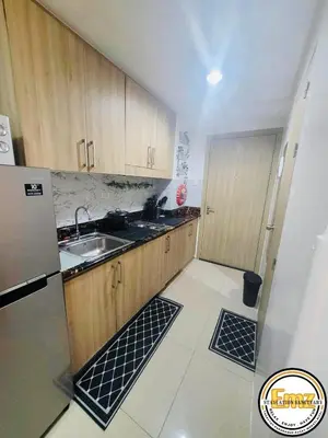 a small kitchen with a sink and a refrigerator at EMZ Shore Staycation 38 in Manila
