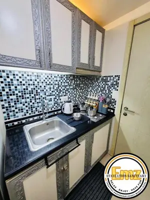 a kitchen with a sink and a tiled wall at EMZ JAZZ Staycation in Manila