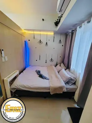 a bedroom with a large bed with lights on it at EMZ JAZZ Staycation in Manila