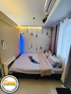 a bed in a room with lights on the wall at EMZ JAZZ Staycation in Manila