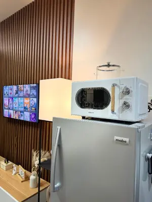 a microwave sitting on top of a refrigerator at The Scandi Hub at Air Residences, Makati in Manila