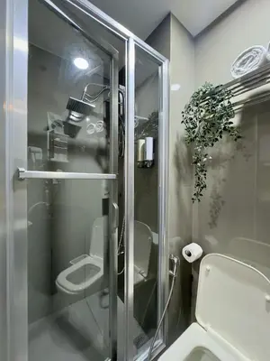a bathroom with a toilet and a glass shower at The Scandi Hub at Air Residences, Makati in Manila