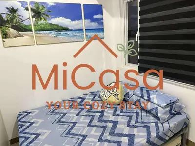 a bedroom with a sign that reads mccassico on the wall at MiCasa South Residences Cozy & Affordable Stay in Manila