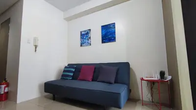 a blue couch with colorful pillows in a room at Shore Residences - 1BR Breezy Home Near the Sea in Manila