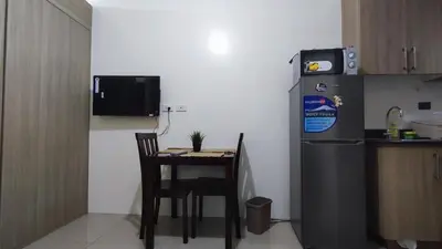 a small kitchen with a table and a refrigerator at Shore Residences - 1BR Breezy Home Near the Sea in Manila