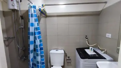 a bathroom with a shower and a toilet and a sink at Shore Residences - 1BR Breezy Home Near the Sea in Manila