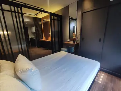 a bedroom with a large white bed and a bathroom at The Auberge at Air Residences Makati! in Manila