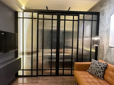 a living room with a couch and a large sliding glass door at The Auberge at Air Residences Makati! in Manila