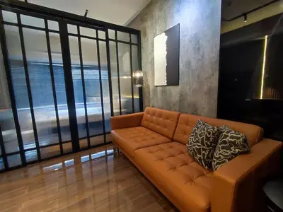 a living room with a couch and large windows at The Auberge at Air Residences Makati! in Manila