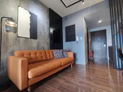 a living room with a brown couch in a room at The Auberge at Air Residences Makati! in Manila