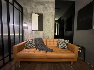 a brown leather couch in a living room at The Auberge at Air Residences Makati! in Manila
