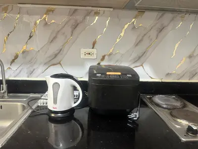 a coffee maker sitting on a counter next to a sink at Azhyuri staycation in Manila