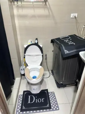 a bathroom with a toilet with a dior sign on it at Azhyuri staycation in Manila