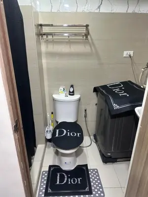 a bathroom with a toilet with a dior sign on it at Azhyuri staycation in Manila
