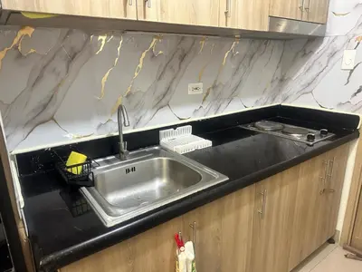 a kitchen with a sink and a counter top at Azhyuri staycation in Manila
