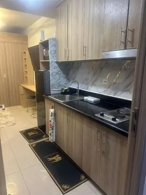 a kitchen with wooden cabinets and a sink at Azhyuri staycation in Manila