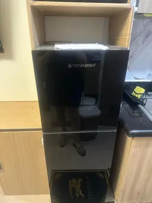 a black refrigerator with a persons reflection in it at Azhyuri staycation in Manila