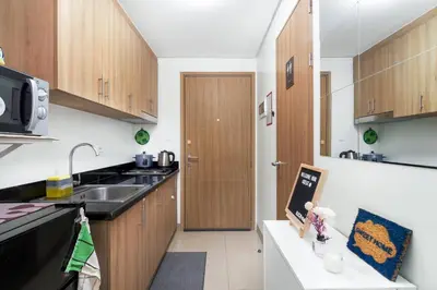 a small kitchen with wooden cabinets and a sink at 1BR Staycation at Shore 2 Tower 3 in Manila
