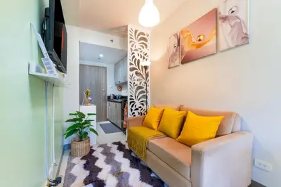 a living room with a couch with yellow pillows at 1BR Staycation at S Residences Tower 1 in Manila