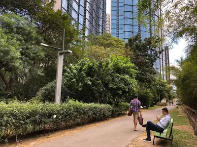 two people sitting on a bench in a park at Huge 101-SQM 2BR in Central BGC Up to 12 Guests in Manila