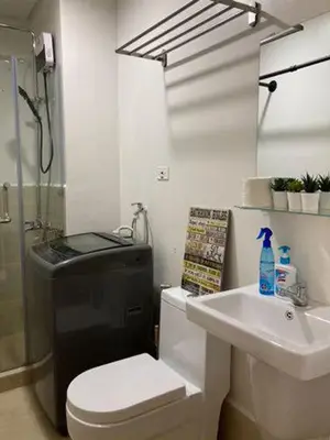 a bathroom with a toilet and a sink and a shower at LEAF RESIDENCES MUNTINLUPA - M&G Staycation in Manila