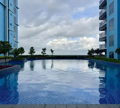 a large swimming pool between two tall buildings at Panoramic Seaview near Airport Facing the Bay 14H in Manila