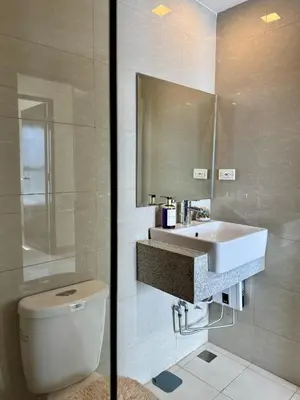 a bathroom with a sink and a toilet and a mirror at Panoramic Seaview near Airport Facing the Bay 14H in Manila