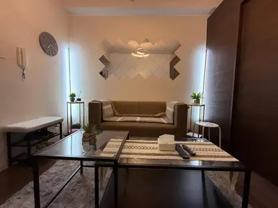 a living room with a couch and a glass table at Iris Affordable and Neat Staycation at Air Residences Makati in Manila