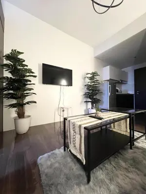 a living room with a table and potted plants at Iris Affordable and Neat Staycation at Air Residences Makati in Manila