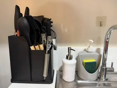 a knife block with utensils on a kitchen counter at Iris Affordable and Neat Staycation at Air Residences Makati in Manila