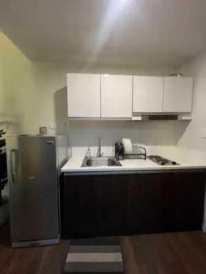 a kitchen with a sink and a refrigerator at Iris Affordable and Neat Staycation at Air Residences Makati in Manila