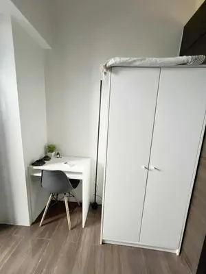 a room with a white cabinet and a desk at Iris Affordable and Neat Staycation at Air Residences Makati in Manila