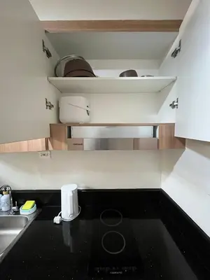 a kitchen with a black counter top and a sink at Chino Roces Makati - No Parking - Red Residences in Manila