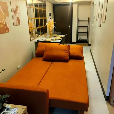 a large bed with orange pillows in a room at Cozy Modernistic 1 BR Uptown BGC in Manila