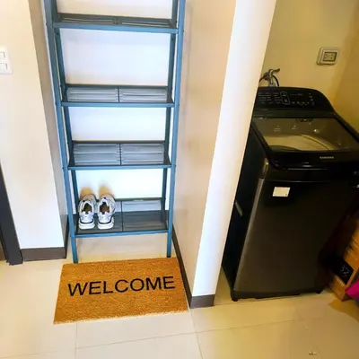 a shelf with a welcome sign next to a refrigerator at Cozy Modernistic 1 BR Uptown BGC in Manila