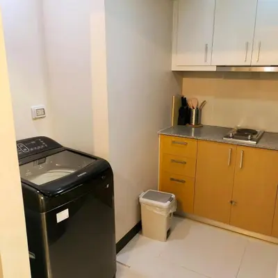 a small kitchen with a trash can and a counter at Cozy Modernistic 1 BR Uptown BGC in Manila