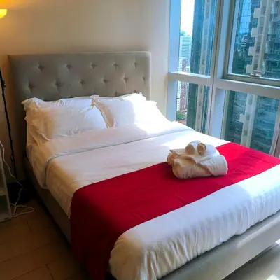a bed with a teddy bear on a red blanket at Cozy Modernistic 1 BR Uptown BGC in Manila