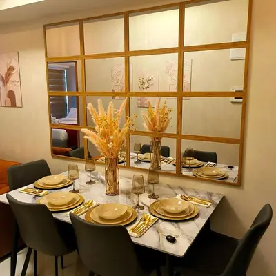 a dining room table with chairs and a large mirror at Cozy Modernistic 1 BR Uptown BGC in Manila