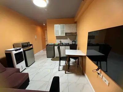 a small kitchen with a table and chairs in a room at Cozy-AIS Staycation in Manila
