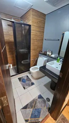 a bathroom with a toilet and a sink and a shower at The Radiance Manila Bay by SonPai in Manila