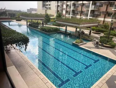 a large blue swimming pool in a building at The Radiance Manila Bay by SonPai in Manila