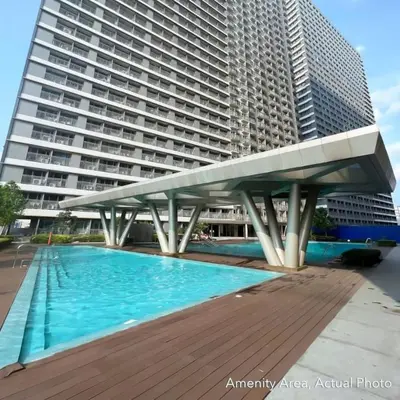 a large building with a swimming pool in front of a building at Your Skyline Hideaway in Manila