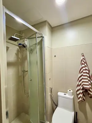 a bathroom with a toilet and a glass shower at Your Skyline Hideaway in Manila