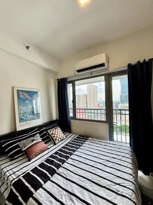 a bedroom with a large bed with a large window at Your Skyline Hideaway in Manila