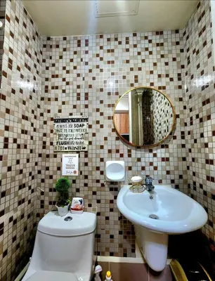 a bathroom with a sink and a toilet and a mirror at Avida Towers Sucat in Manila